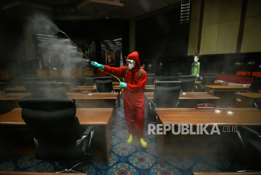 Petugas menyemprotkan cairan disinfektan di ruang sidang paripurna DPRD DKI Jakarta, Rabu (29/7/2020). Penerapan protokol kesehatan harus tetap dilakukan saat berada di kantor. Ilustrasi.