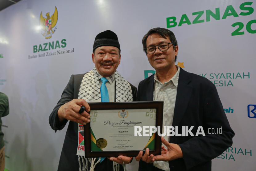 Ketua Badan Amil Zakat Nasional (Baznas) RI Noor Achmad (kiri) menyerahkan penghargaan kepada Pemimpin Redaksi Republika Andi Muhyiddin (kanan) saat acara Baznas Award 2025 di Jakarta, Kamis (28/8/2025). Republika berhasil meraih penghargaan dari Baznas RI sebagai Media Online Pewarta Gerakan Zakat Terbaik pada ajang Baznas Award 2025.