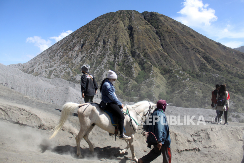 Pemilik mengantarkan pengunjung berkuda di Gunung Bromo, Probolinggo, Jawa Timur, Ahad (13/6/2021). Imbas Harga BBM Naik, Tarif Sewa Jip di Kawasan Bromo Naik Rp 100 Ribu