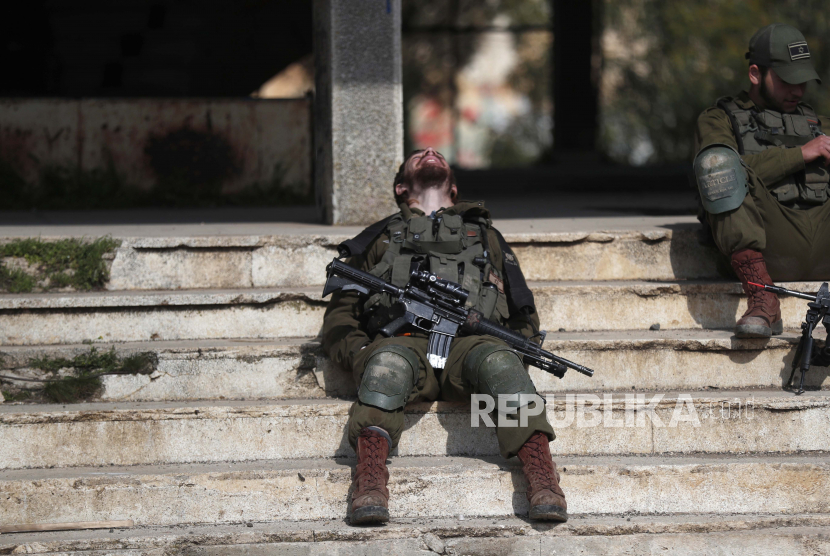 Tentara Israel beristirahat selama pelatihan di sebuah bangunan terbengkalai yang dulunya adalah markas tentara Suriah di Quneitra sebelum diambil alih oleh Israel, di Dataran Tinggi Golan, 15 Februari 2021. 