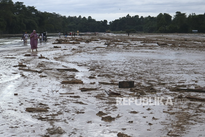 Sejumlah warga melintasi lumpur akibat banjir bandang yang menutupi landasan pacu di Bandara Andi Jemma Masamba, Luwu Utara, Selasa (14/7/2020). Banjir bandang yang terjadi pada Senin (13/7/2020) tersebut mengakibatkan sejumlah fasilitas bandara terendam banjir dan berdampak pada lumpuhnya operasional penerbangan. ANTARA FOTO/HO/dok Kemenhub/wpa/hp.