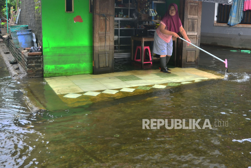 Warga membersihkan lantai rumahnya dari sisa banjir di Kudus, Jawa Tengah. 