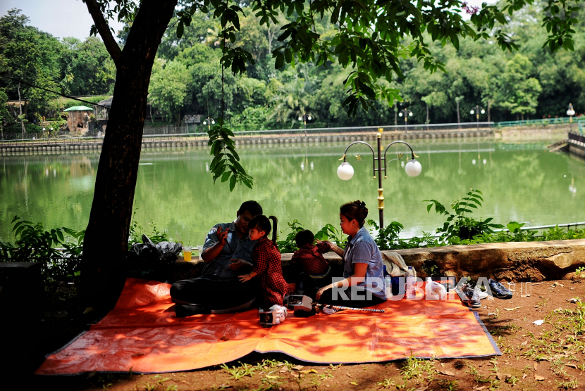 Pengunjung menikmati liburan di area Taman Margasatwa Ragunan (TMR), Jakarta Selatan dengan berlatarbelakang salah satu waduk yang ada di dalam TMR (ilustrasi)