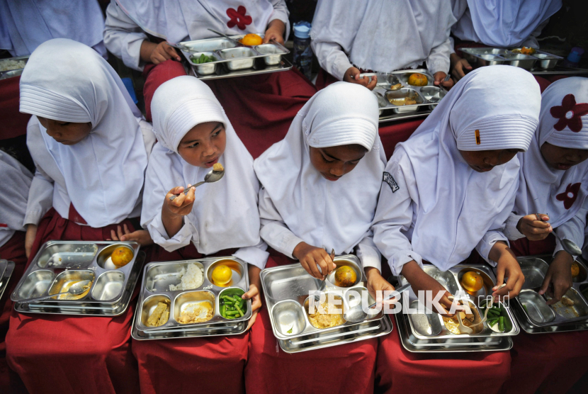 Para siswa menyantap hidangan Makan Bergizi Gratis (MBG) di SDN 05 Sukatani, Depok, Jawa Barat, Senin (6/1/2025). 