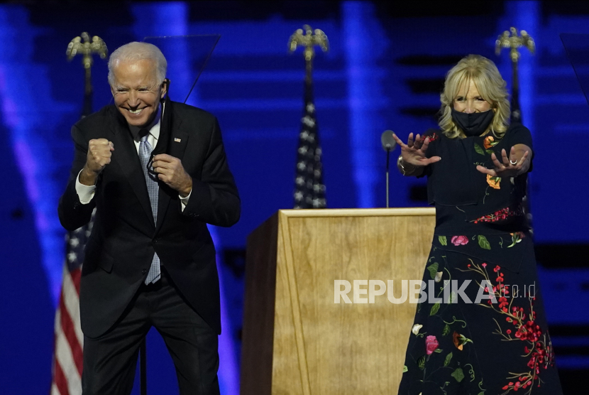  Presiden terpilih Joe Biden dan istrinya Jill Biden memberi isyarat kepada pendukung Sabtu, 7 November 2020, di Wilmington, Del.