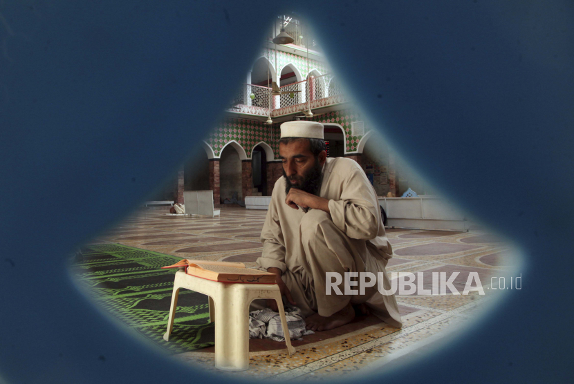 Seorang Muslim Pakistan membaca Alquran pada hari pertama Ramadhan di sebuah masjid, di Peshawar, Pakistan, Ahad, 3 April 2022. Menteri Agama Pakistan: Islam tidak Pernah Memaksa Seseorang Menjadi Mualaf