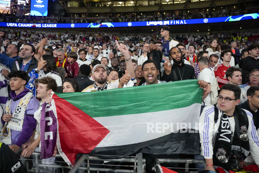 Suporter Real Madrid mengibarkan bendera Palestina usai laga final sepak bola Liga Champions antara Borussia Dortmund melawan Real Madrid di stadion Wembley London,  Ahad (2/6/2024) dini hari WIB.