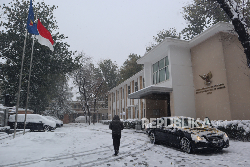 Seorang staf berjalan di halaman Kedutaan Besar RI yang berselimut salju, di Beijing, China, Ahad (7/11/2021). Akibat badai salju, Otoritas China mengeluarkan peringatan dini kepada masyarakat setempat untuk mewaspadai rendahnya suhu udara pada musim dingin tahun ini yang lebih ekstrem dibandingkan musim dingin pada tahun-tahun sebelumnya. 