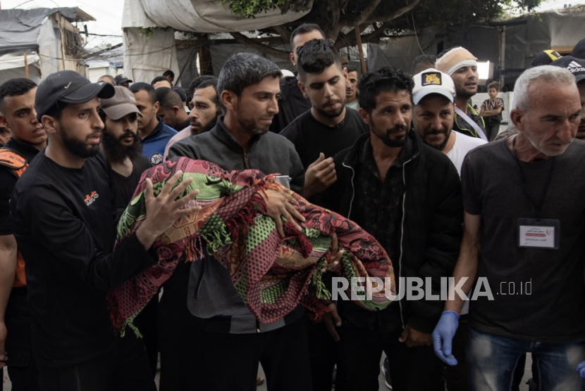 Kerabat warga Palestina yang syahid akibat serangan udara Israel di kamp Al Nuseirat, di luar Rumah Sakit Syuhada al-Aqsa di Deir al-Balah,  Selasa (14/5/2024).