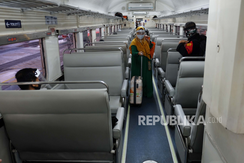 Penumpang memakai masker dan pelindung wajah (Face Shield) di Kereta Api (KA) Ranggajati relasi Cirebon-Jember saat transit di Stasiun Balapan, Solo, Jawa Tengah, Ahad (14/6/2020). 