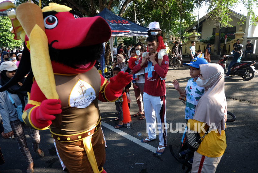 Warga menyaksikan kirab untuk mengenalkan maskot dan logo ASEAN Para Games XI 2022 saat peluncuran di Jalan Slamet Riyadi, Solo, Jawa Tengah, Ahad (3/7/2022). Indonesia menjadi tuan rumah ajang ASEAN Para Games XI 2022 yang akan diikuti 11 negara Asia Tenggara pada 30 Juli-6 Agustus 2022 di Solo, Jawa Tengah. 