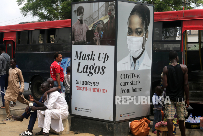 Orang-orang berjalan melewati papan iklan berbentuk kotak di Nigeria. Sebanyak 150 orang dirawat di rumah sakit usai mengalami gejala diare di Nigeria. Ilustrasi.
