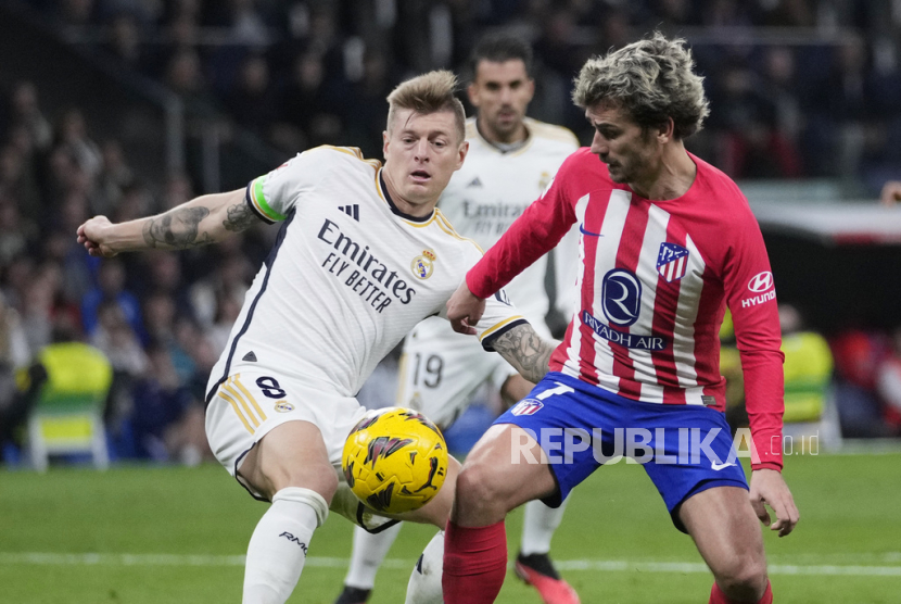 Atletico Madrid Antoine Griezmann, right, and Real Madrid Toni Kroos challenge for the ball during the Spanish La Liga soccer match between Real Madrid and Atletico Madrid at the Santiago Bernabeu stadium in Madrid, Spain, Sunday, Feb. 4, 2024.