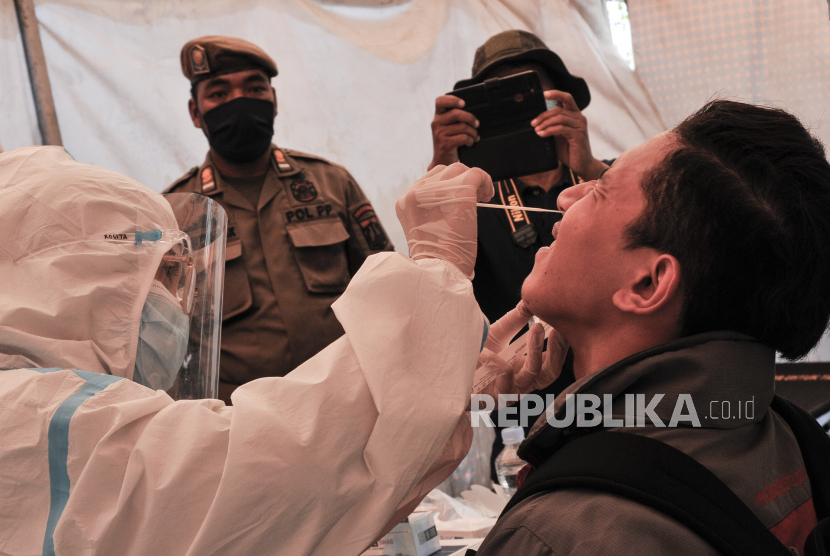 Petugas medis melakukan tes usap (swab test) ke warga yang tidak menggunakan masker. (ilustrasi)