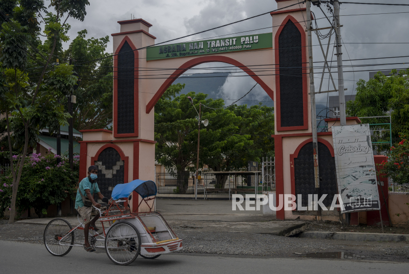 Pengendara becak melintas di depan Kompleks Asrama Haji Transit, Palu, Sulawesi Tengah.