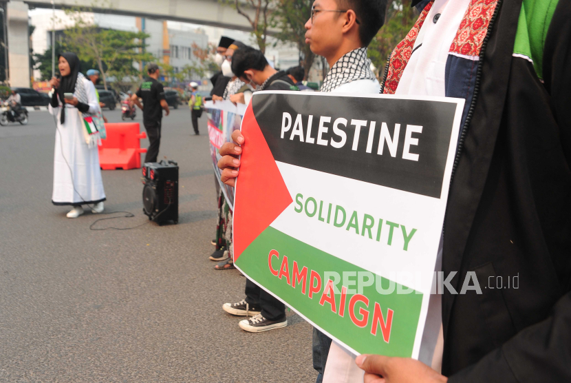 Sejumlah peserta aksi  menunjukkan poster yang bertulis solidaritas terhadap Palestina di simpang lima DPRD Provinsi Sumsel Palembang, Sumsel, Senin (16/10/2023). Aksi yang diikuti puluhan Aliansi Pemuda Sumsel  Bergerak ini mengecam tindakan Israel terhadap Palestina.