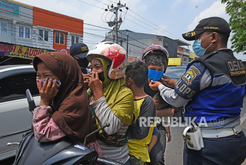 Petugas Dinas Perhubungan memasangkan masker kepada warga yang melanggar Perda Wajib Memakai Masker di Tempat Umum  (ilustrasi)