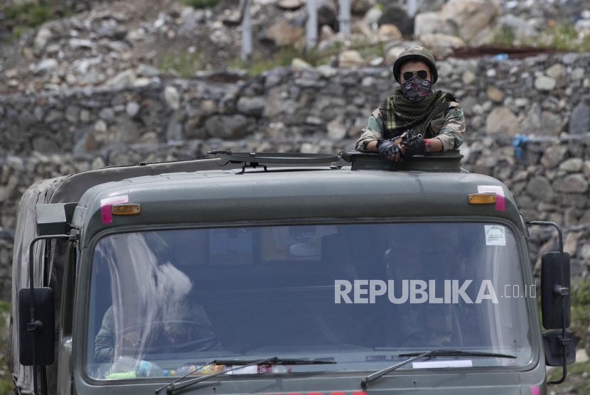 Seorang prajurit tentara India berjaga di salah satu kendaraan saat konvoi di jalan raya Srinagar-Ladakh di Gagangeer, India, Rabu (17/6). Pasukan keamanan India mengatakan tidak ada pihak yang melepaskan tembakan dalam bentrokan di wilayah Ladakh Senin malam