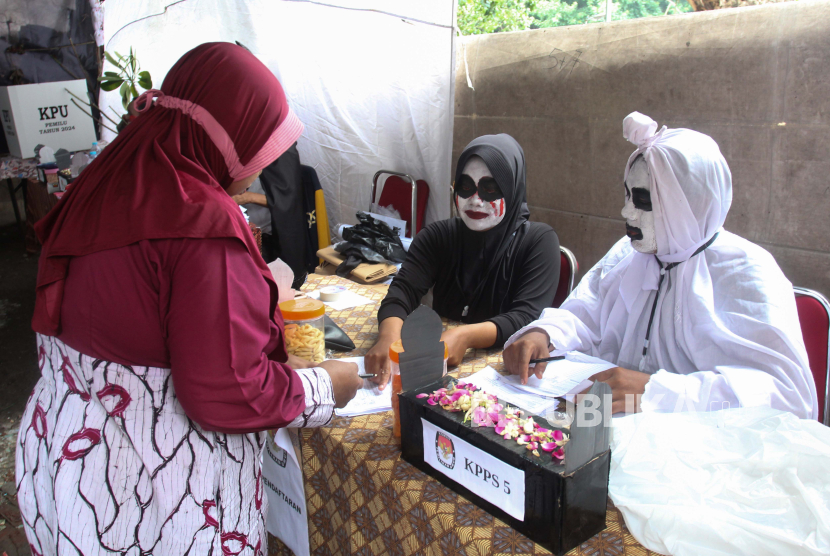 Petugas KPPS mengenakan kostum hantu melayani warga saat pemungutan suara Pemilu 2024. Bawaslu Kota Surabaya sebut 8 TPS berpotensi untuk melakukan pencoblosan ulang.
