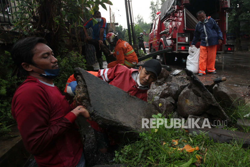 Petugas mengangkat pecahan beton yang menyumbat saluran air di Jalan Ngagel Timur, Surabaya, Jawa Timur. Pemkot Surabaya menekankan pentingnya konektivitas saluran air untuk mencegah banjir.