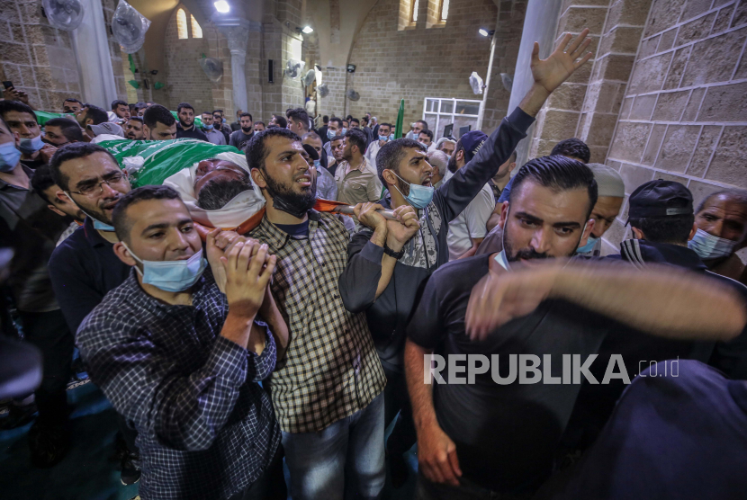 Warga Palestina menghadiri pemakaman 15 orang yang tewas dalam serangan udara Israel di Kota Gaza, 13 Mei 2021. 