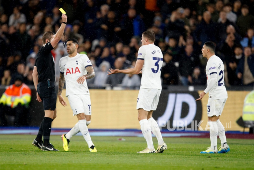 Referee John Brooks (L) gives a yellow card to Mickey van de Ven (2-R) of Tottenham during the English Premier League match between West Ham United and Tottenham Hotspur in London, Britain, 02 April 2024. 