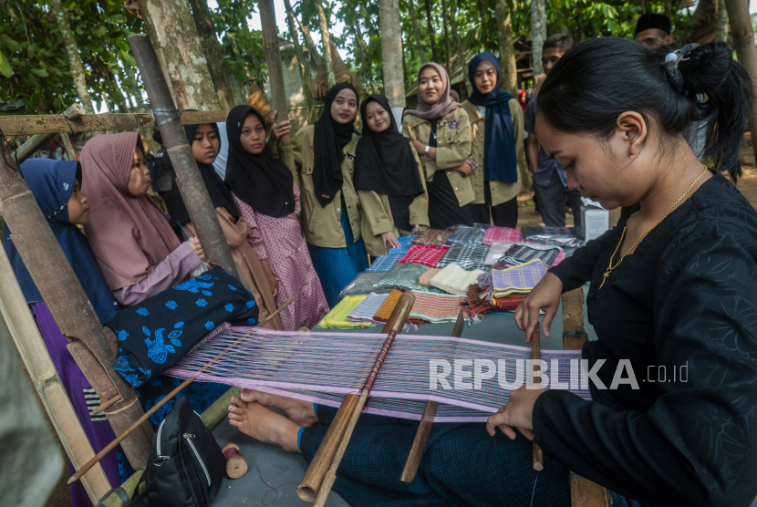 Warga mengamati pembuatan kain tenun Suku Baduy di Rangkasbitung, Lebak, Banten. Permintaan tenun khas dari suku Badui mulai kembali normal.