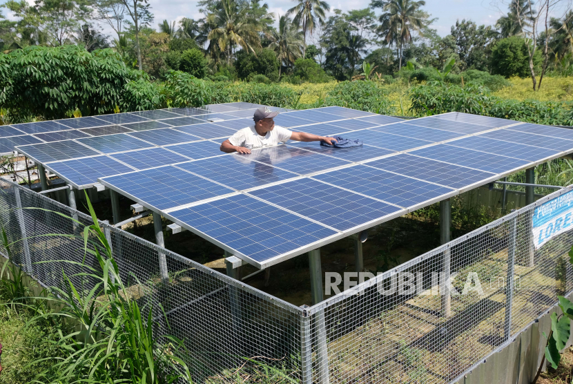 Seorang warga membersihkan permukaan panel surya saat perawatan rutin pembangkit listrik tenaga surya (PLTS) di persawahan desa Sugihmas, Grabag, Magelang, Jawa Tengah. 