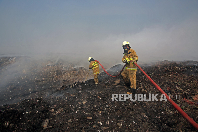Petugas pemadam kebakaran DKI Jakarta melakukan pendinginan gunungan sampah yang terbakar di tempat pembuangan akhir (TPA) Rawa Kucing, Neglasari, Kota Tangerang, Banten.