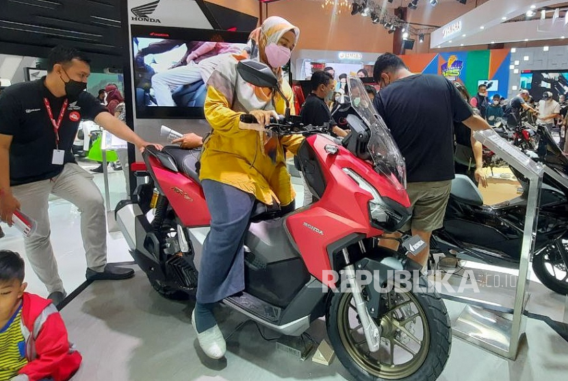 Seorang pengunjung mencoba duduk di atas sepeda motor Honda ADV 160 buatan Jepang selama Indonesia Motorcycle Show (IMOS) di Jakarta, Indonesia, 06 November 2022. Menurut penyelenggara, Asosiasi Industri Sepeda Motor Indonesia (AISI), IMOS 2022 akan menampilkan yang terbaru inovasi dari merek sepeda motor terkemuka. AISI melaporkan jumlah penjualan sepeda motor di pasar domestik sebanyak 524.821 unit pada Agustus 2022, angka tertinggi sejak Maret 2020. 