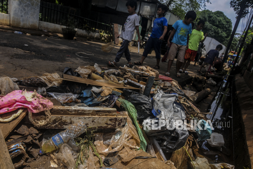 Anak-anak melintas di dekat tumpukan sampah di [inggir jalan (ilustrasi)