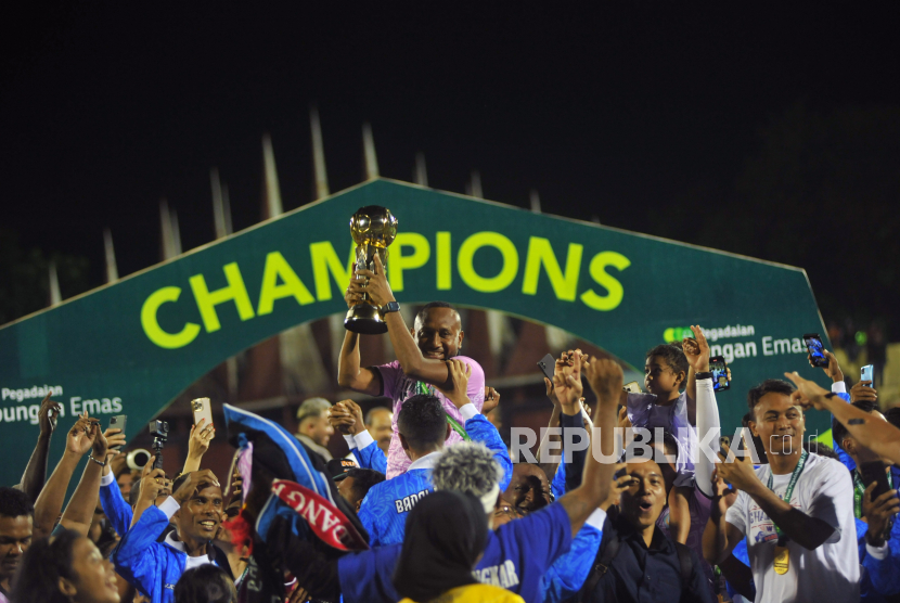 Pesepak bola PSBS Biak dan ofisial mengangkat piala usai menjadi juara pertama Liga 2 di Stadion GOR H Agus Salim Padang, Sumatera Barat, Sabtu (9/3/2024).