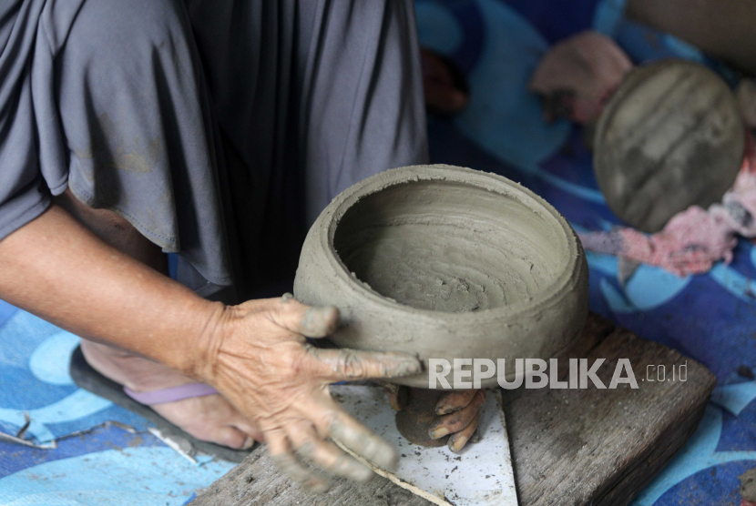 Seorang perempuan membuat pot dan piring dari tanah liat di sebuah bengkel gerabah tradisional di Banda Aceh, Selasa (1/12). Kementerian Perindustrian terus mendorong optimalisasi Tingkat Komponen Dalam Negeri (TKDN) pada setiap produk industri nasional.