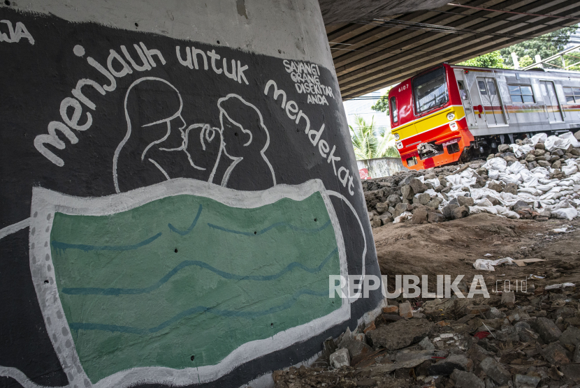 KRL melintas di dekat mural bertema pencegahaan penyebaran virus Corona atau COVID-19 di Jakarta, Rabu (1/4/2020). Akibat virus corona diperkirakan 5-25 juta orang kehilangan pekerjaannya sementara di seluruh dunia.