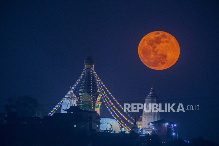Bulan Supermoon atau super Pink Moon muncul di belakang Stupa Swayambhunath di Kathmandu, Nepal, 27 April 2021. Bulan purnama super dinamai demikian karena letaknya paling dekat dengan bumi dan dengan demikian tampak lebih besar dari bulan purnama normal. Jangan Lewatkan Fenomena Supermoon Pink Akhir Pekan Ini