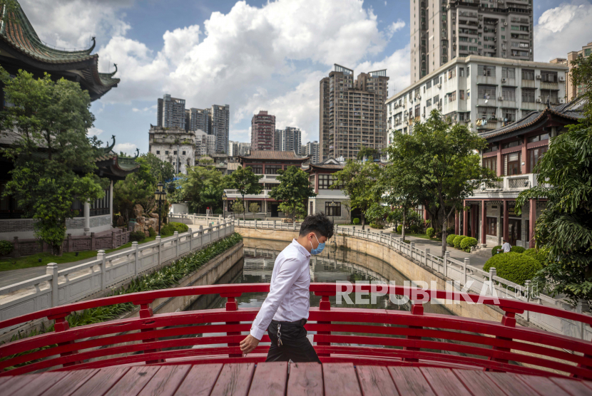 China Tutup Permukiman Setelah Muncul Lonjakan Covid-19. Seorang pria dengan mengenakan masker melintasi jembatan di Guangzhou, Cina, Senin (22/6). Cina berlomba untuk menahan gelombang kedua kasus Covid-19 yang kebanyakan berada di Beijing. EPA-EFE / ALEX PLAVEVSKI