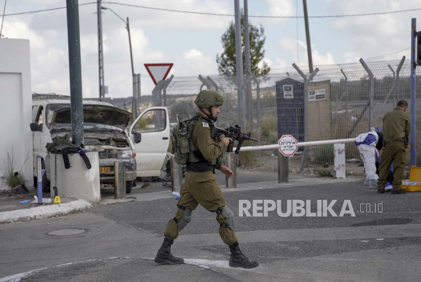 Tentara Israel mengamankan lokasi serangan tabrak mobil di pos pemeriksaan Maccabim di Tepi Barat, dekat pemukiman Israel Beit Horon, Rabu, 2 November 2022. Israel mengutuk dan Palestina menyambut pemungutan suara Majelis Umum Perserikatan Bangsa-Bangsa (MU PBB) yang dilakukan pada Jumat (30/12/2022).