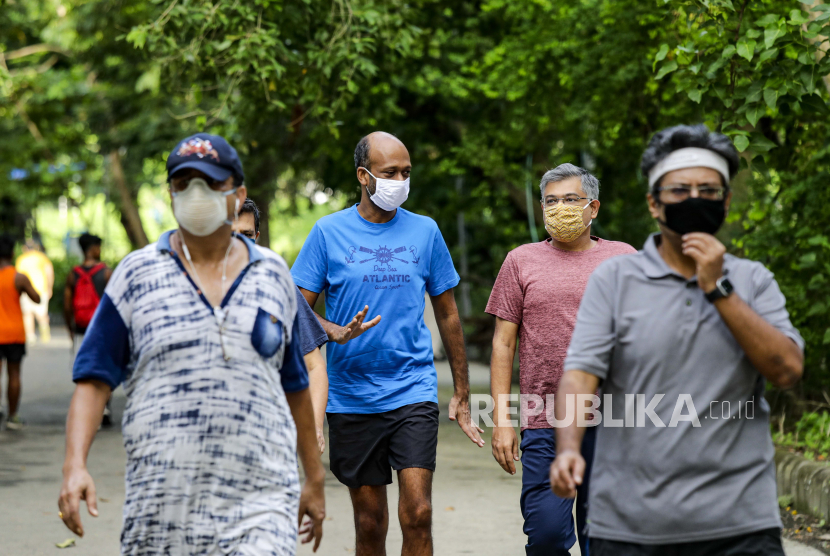 Masyarakat berjalan di pagi hari dengan menggunakan masker untuk mencegah penyebaran virus corona di sebuah taman di Kolkata, India, Selasa, 15 September 2020. Jalan kaki termasuk olahraga yang memiliki banyak manfaat.