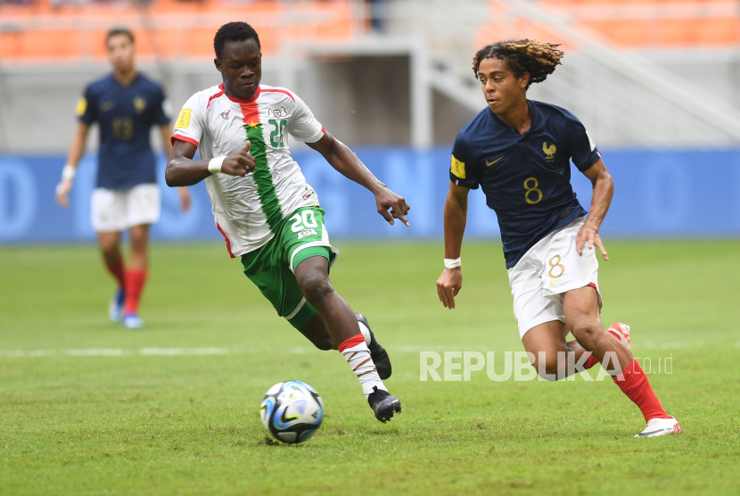 Pesepak bola timnas Burkina Faso Emmanuel Ouedraogo (kiri) berebut bola dengan pesepak bola timnas Prancis Saimon Bouabre pada laga penyisihan Grup E Piala Dunia U-17 2023 di Jakarta International Stadium, Jakarta, Ahad (12/11/2023). 