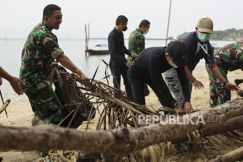 Wakil Wali Kota Batam Amsakar Achmad (kiri kedua) bersama Pasiter Kodim 0316/Batam Kapten Inf TM Tarigan (kiri) membersihkan sampah di kawasan wisata Pantai Nongsa, Batam, Kepulauan Riau, Rabu (11/5/2022). Aksi bersih-bersih yang di ikuti dari TNI AD, TNI AL, pihak Kepolisian, pelajar dan instansi pemerintahan tersebut guna menjaga kebersihan dan lingkungan, terutama di kawasan publik. 