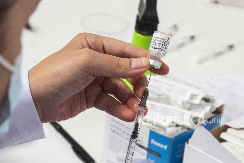  Seorang perawat menyiapkan dosis vaksin Pfizer-BioNtech terhadap COVID-19 selama vaksinasi di Arena 