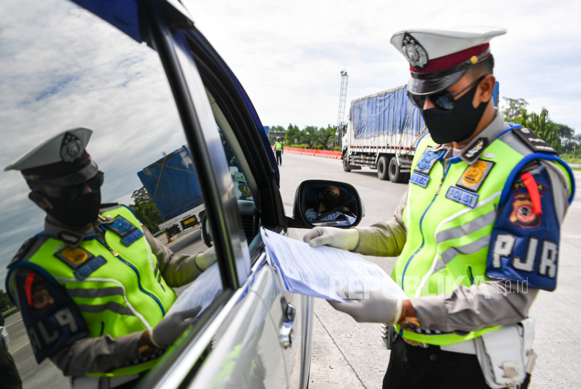 Petugas memeriksa kendaraan yang melintas di pintu tol.  Pemeriksaan tersebut sebagai upaya penyekatan gelombang pemudik jelang perayaan Hari Raya Idul Fitri 1441 H dari arah Jakarta menuju Jawa Tengah