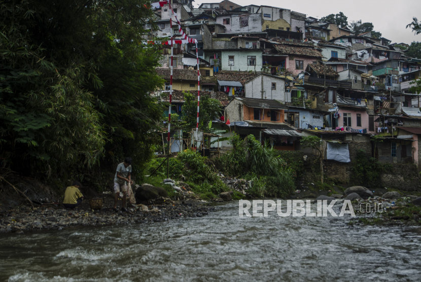 Warga memunguti sampah di bantaran sungai Cikapundung, Bandung, Jawa Barat, Jumat (29/1). Pemerintah mengklaim kebijakan yang dilakukan pemerintah sejak pandemi Covid-19 berhasil mengendalikan angka kemiskinan.