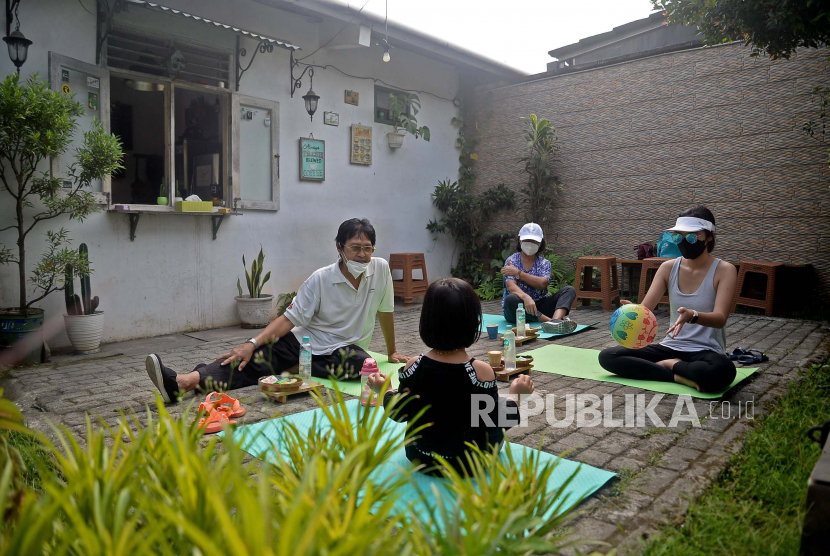 Pengunjung berserta keluarganya menikmati makanan ringan dan kopi sambil berjemur di halaman Kedai Nyambi Ngopi, Depok, Jawa Barat, Jumat (30/7). Berjemur merupakan salah satu cara mendapatkan vitamin D.