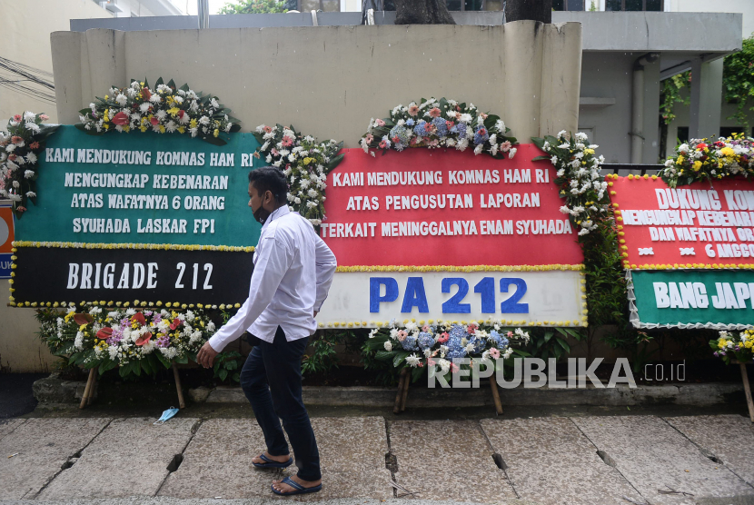 Pegawai melintas di dekat karangan bunga di kantor Komnas HAM, Jakarta, Senin (14/12). Karangan bunga berisi pesan dukungan dan penyemangat untuk Komnas HAM yang tengah mengusut peristiwa meninggalnya 6 Anggota FPI.Prayogi/Republika.