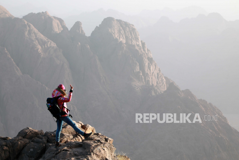  Seorang turis menyaksikan matahari terbit di luar gereja di puncak Gunung Moses, kota Saint Catherine, Sinai Selatan, Mesir, 20 Maret 2021 (dikeluarkan 22 Maret 2021).