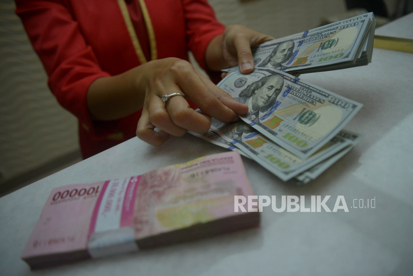 Karyawan menghitung uang rupiah dan dolar AS di salah satu gerai penukaran mata uang asing di Jakarta, Kamis (29/9/2022). Rupiah pada Senin (2/5/2023) pagi bertahan di posisi Rp 14.674 per dolar AS
