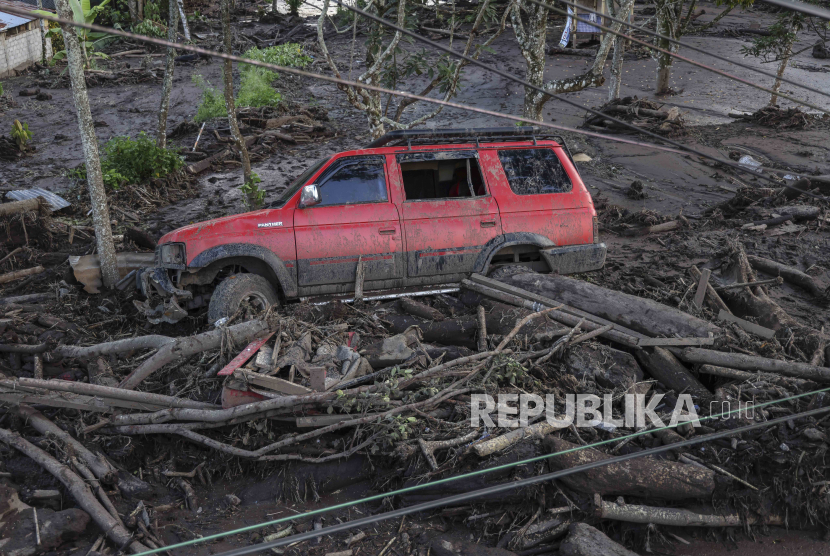 Sebuah mobil tersapu banjir bandang di Tanah Datar, Sumatera Barat, Ahad (12/5/2024). BMKG merekomendasikan teknologi modifikasi cuaca di Sumbar.