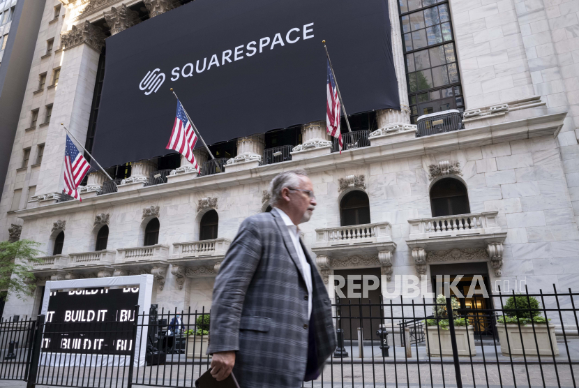 Pembatasan Covid-19 mulai dicabut di Amerika Serikat. Seorang pria berjalan melewati spanduk untuk Squarespace di Bursa Efek New York, Amerika Serikat. 