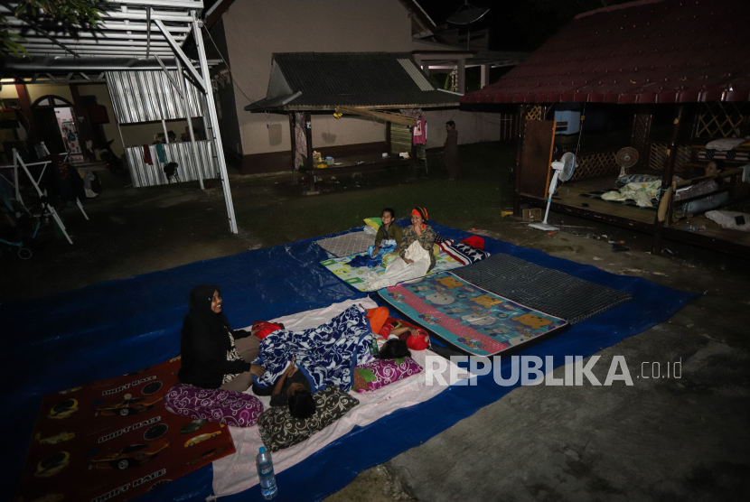 Warga mengungsi di halaman rumahnya pascagempa di Sangkapura, Pulau Bawean, Gresik, Jawa Timur, Sabtu (23/3/2024). Sebagian warga korban gempa bumi memilih mengungsi di halaman rumah mereka untuk mengantisipasi terjadinya gempa susulan. 